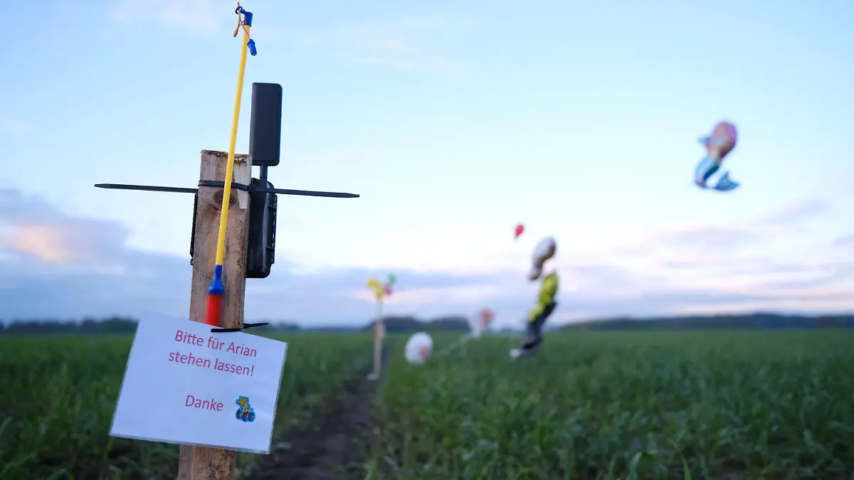 24.04.2024, Niedersachsen, Bremervörde: Ballons, Süßigkeiten und eine Wildkamera stehen auf einem Feld bei Bremervörde. Von einem vermissten sechs Jahre alten Jungen aus dem niedersächsischen Bremervörde fehlt noch immer jede Spur. Foto: Markus Hibbeler/dpa +++ dpa-Bildfunk +++