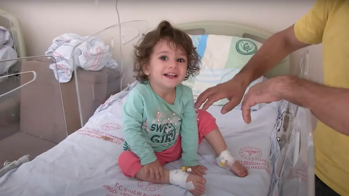 A girl, 2, sits on a hospital bed in Bingol, Turkey, in undated video. She allegedly bit a snake that bit her. (Newsflash)