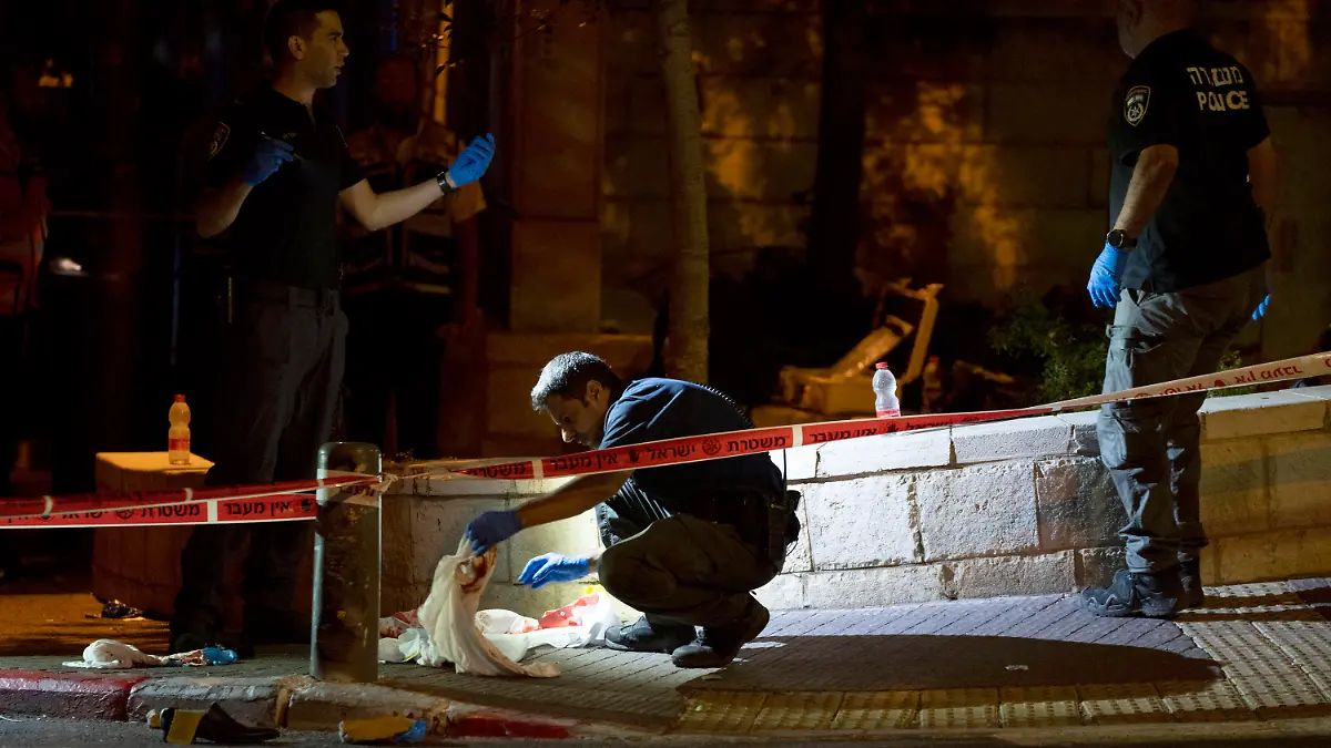 Israeli police crime scene investigators work at the scene of a shooting attack that wounded several Israelis near the Old City of Jerusalem, early Sunday, Aug. 14, 2022. Israeli police and medics say a gunman opened fire at a bus in a suspected Palestinian attack that came a week after violence flared up between Israel and militants in Gaza. (AP Photo/ Maya Alleruzzo)
