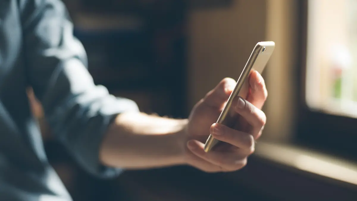 Hipster using a touch screen smart phone hands close up, vintage colors