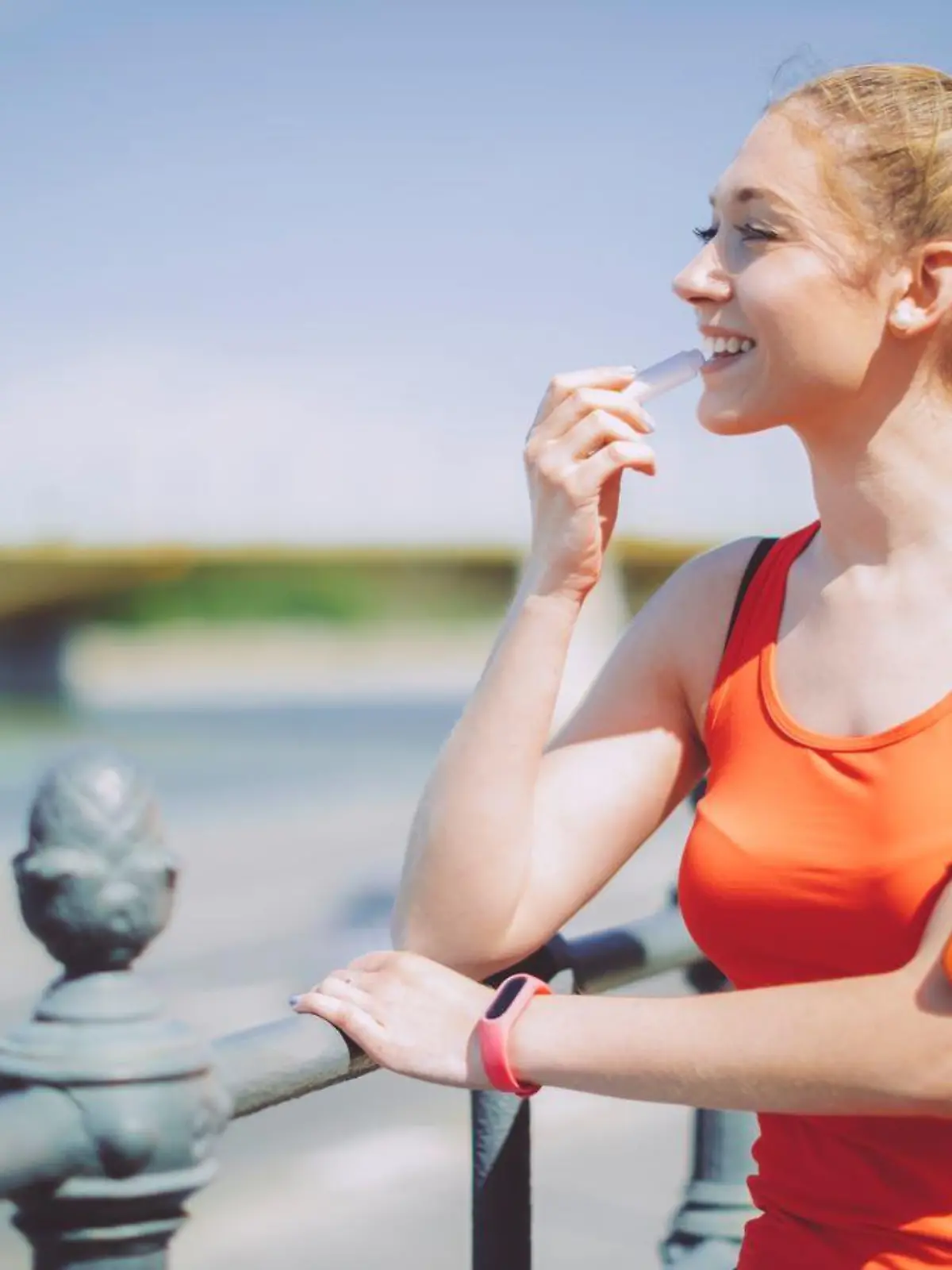 Frau nutzt Lippenstift beim Sport