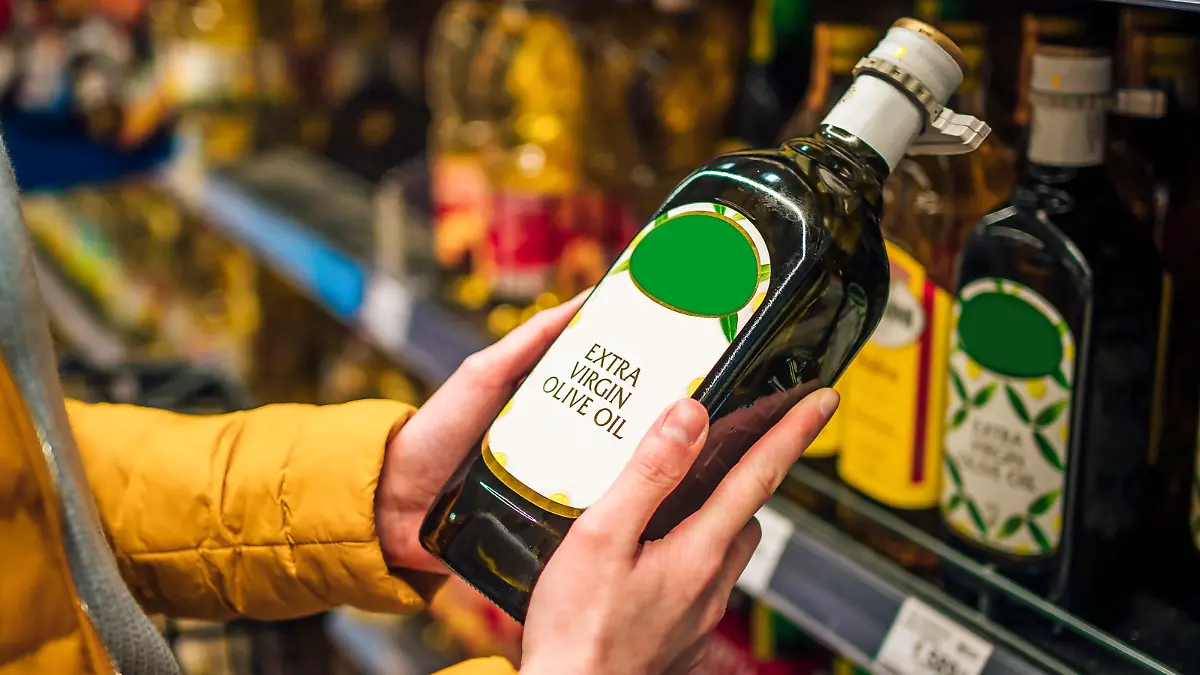 Woman buying olive oil from supermarket.. She's choosing from the shelf
