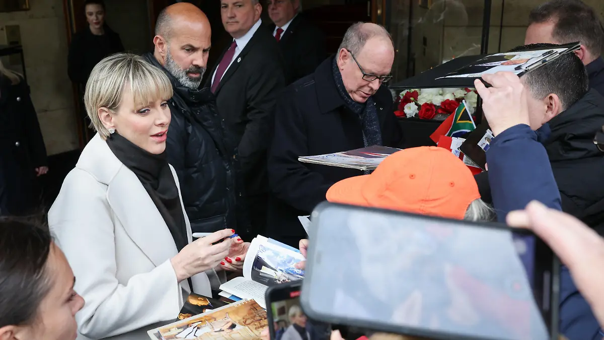 25.04.2024, Hamburg: Charlene Lynette Grimaldi, Fürstin von Monaco, und Albert II. Fürst von Monaco (r) kommen am Hotel Vier Jahreszeiten an und geben Autogramme. Die Fürstenfamilie ist zur Eröffnung der neuen Monaco-Welt im Miniatur Wunderland in Hamburg. Foto: Christian Charisius/dpa +++ dpa-Bildfunk +++