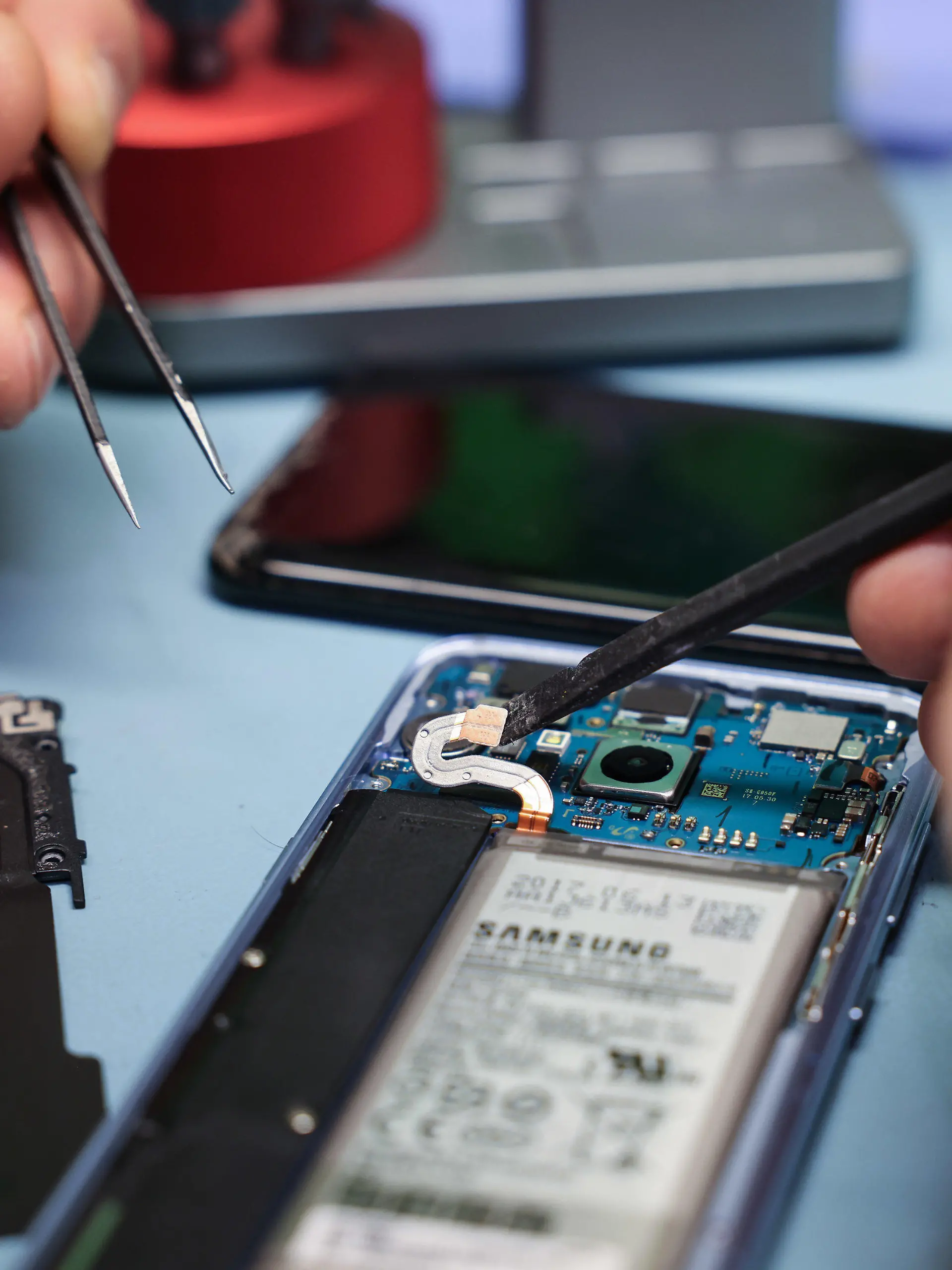 23.04.2024, Hamburg: Ein Techniker arbeitet an einem Smartphone mit defektem Display in seinem kleinen Fachgeschäft für Reparaturen und Zubehör. In der EU sollen Kunden in Zukunft das Recht haben, bestimmte Geräte reparieren zu lassen. Mit der neuen Regelung soll gewährleistet werden, dass Produkte länger genutzt werden und weniger Müll produziert wird. Foto: Christian Charisius/dpa +++ dpa-Bildfunk +++