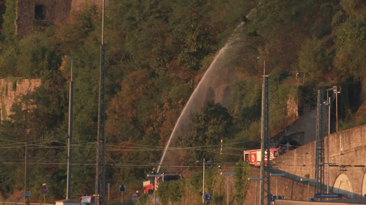 13.08.2022, Rheinland-Pfalz, Koblenz: Feuerwehrleute bewässern vor dem Abschlussfeuerwerk von Rhein in Flammen den Hang der Festung Ehrenbreitstein. Aufgrund der Trockenheit besteht Brandgefahr. Entlang der schönsten Rheinabschnitte finden jährlich von Mai bis September die Feuerwerksspektakel «Rhein in Flammen» statt. Foto: Thomas Frey/dpa +++ dpa-Bildfunk +++