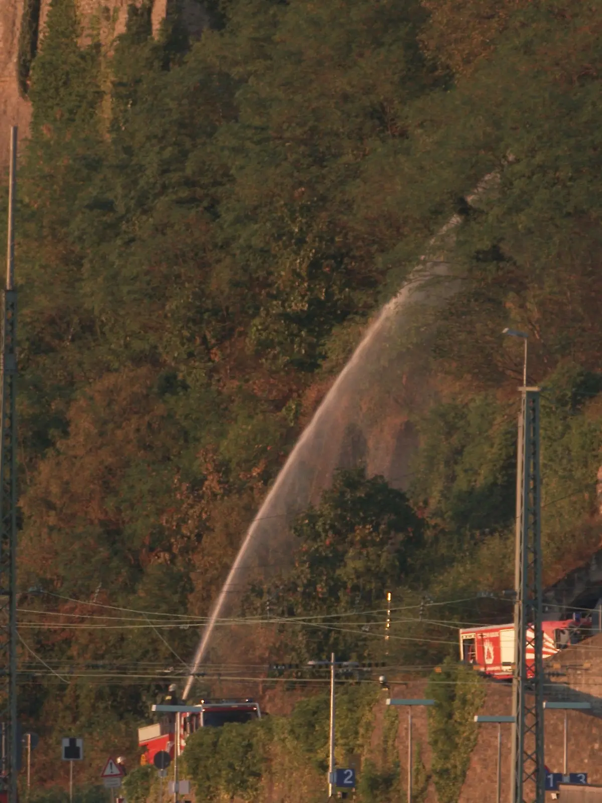13.08.2022, Rheinland-Pfalz, Koblenz: Feuerwehrleute bewässern vor dem Abschlussfeuerwerk von Rhein in Flammen den Hang der Festung Ehrenbreitstein. Aufgrund der Trockenheit besteht Brandgefahr. Entlang der schönsten Rheinabschnitte finden jährlich von Mai bis September die Feuerwerksspektakel «Rhein in Flammen» statt. Foto: Thomas Frey/dpa +++ dpa-Bildfunk +++