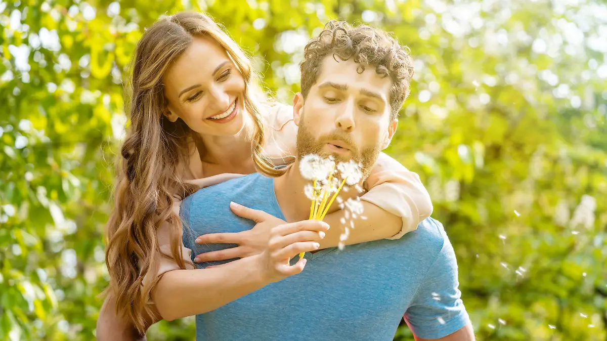 Woman and man on a meadow in romantic mood enjoying themselves and their life