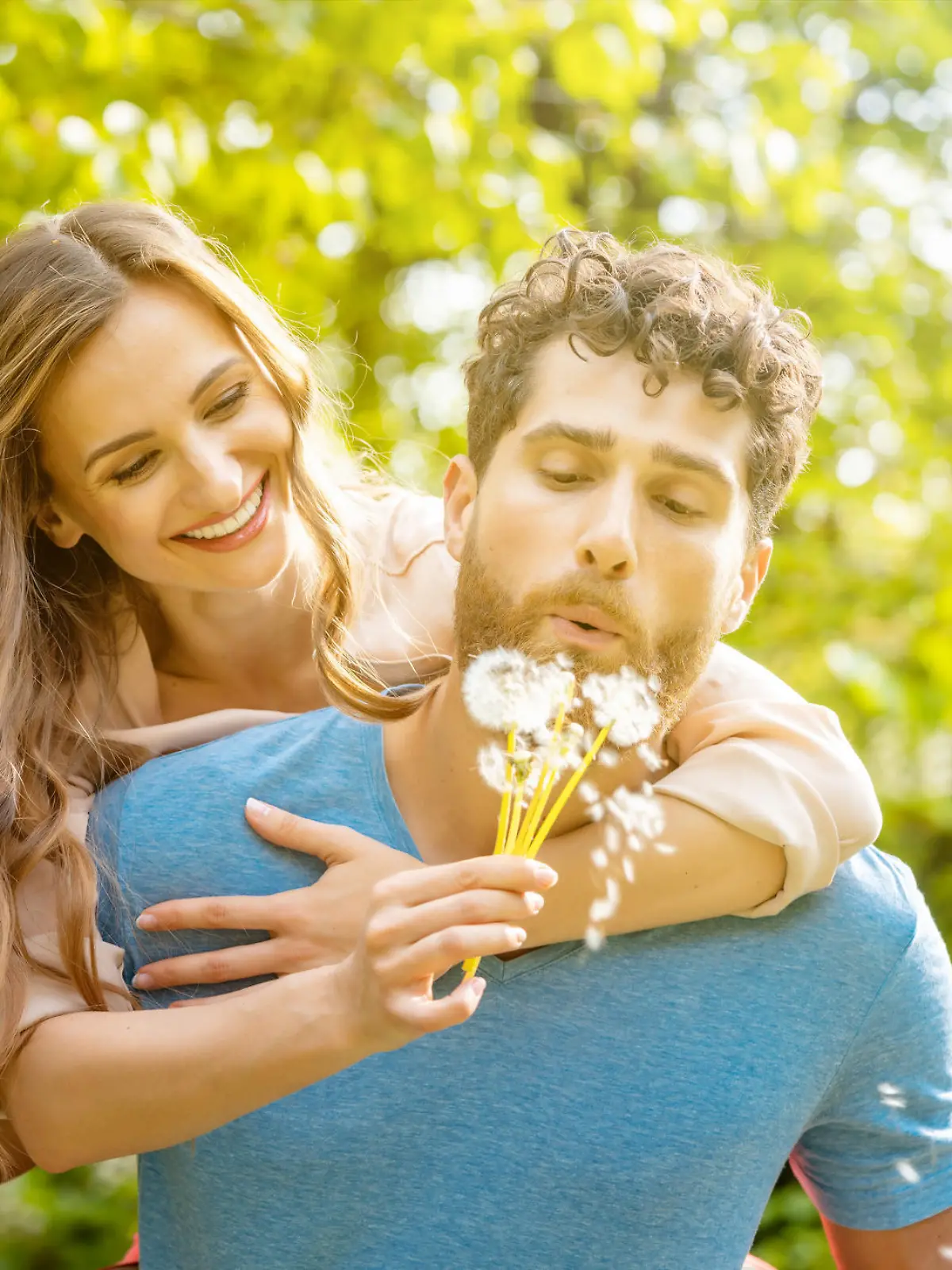Woman and man on a meadow in romantic mood enjoying themselves and their life