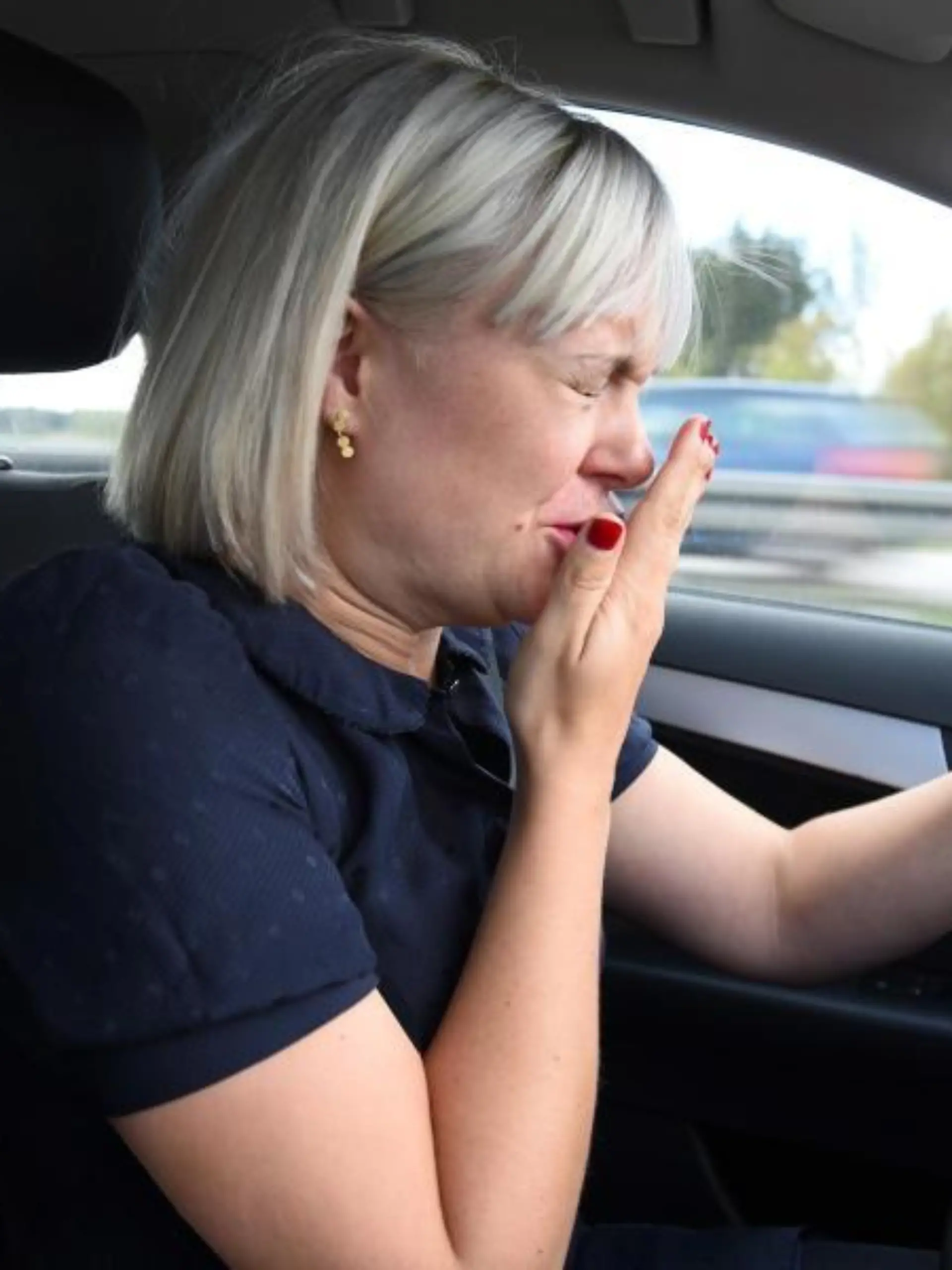Autofahrerin während einer Niesattacke