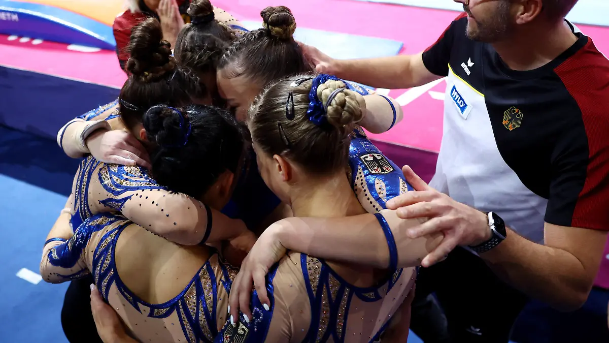 2022 European Championships - Artistic Gymnastics - Olympiahalle, Munich, Germany - August 13, 2022 Germany's Sarah Voss, Pauline Schaefer-Betz, Emma Leonie Malewski, Elisabeth Seitz and Bui Kim celebrate with coach winning the women's team final REUTERS/Kai Pfaffenbach