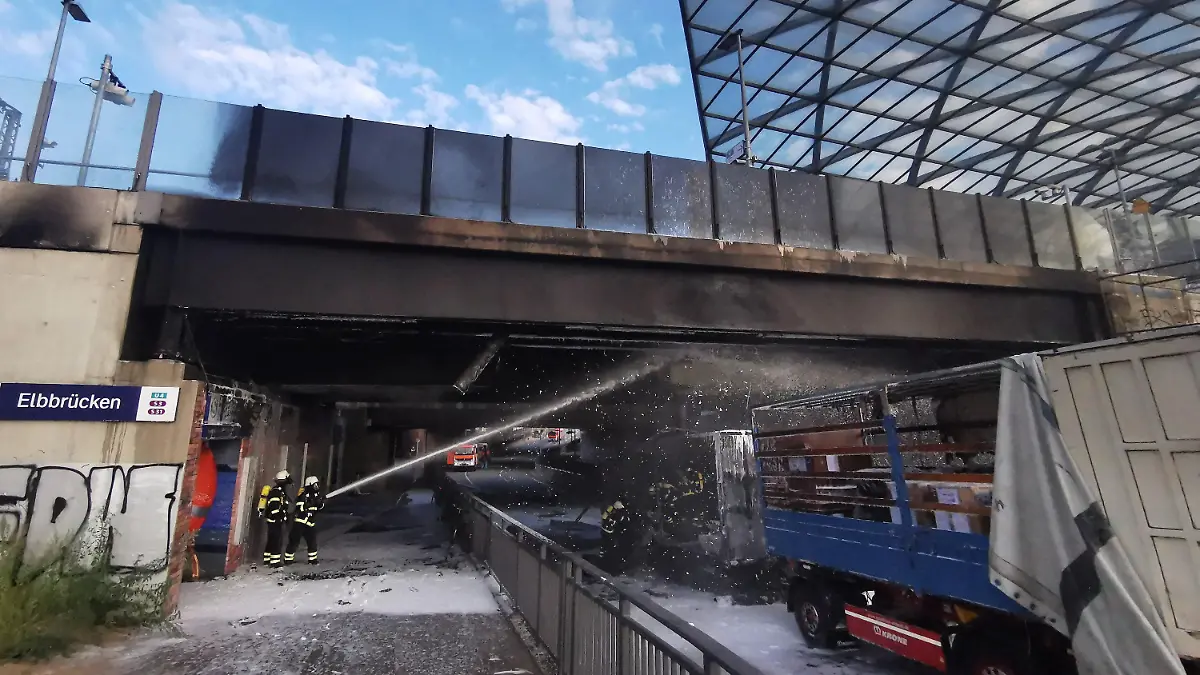08.08.2022, Hamburg: Feuerwehrleute löschen am Bahnhof Elbbrücken einen brennenden Lkw. Wegen des Lastwagen-Brandes unter der Zugbrücke in Hamburg hat es am Montagmorgen Einschränkungen im Bahnverkehr gegeben. (zu dpa "Lastwagen brennt an Elbbrücken: Bahnverkehr eingeschränkt") Foto: Steven Hutchings/dpa +++ dpa-Bildfunk +++