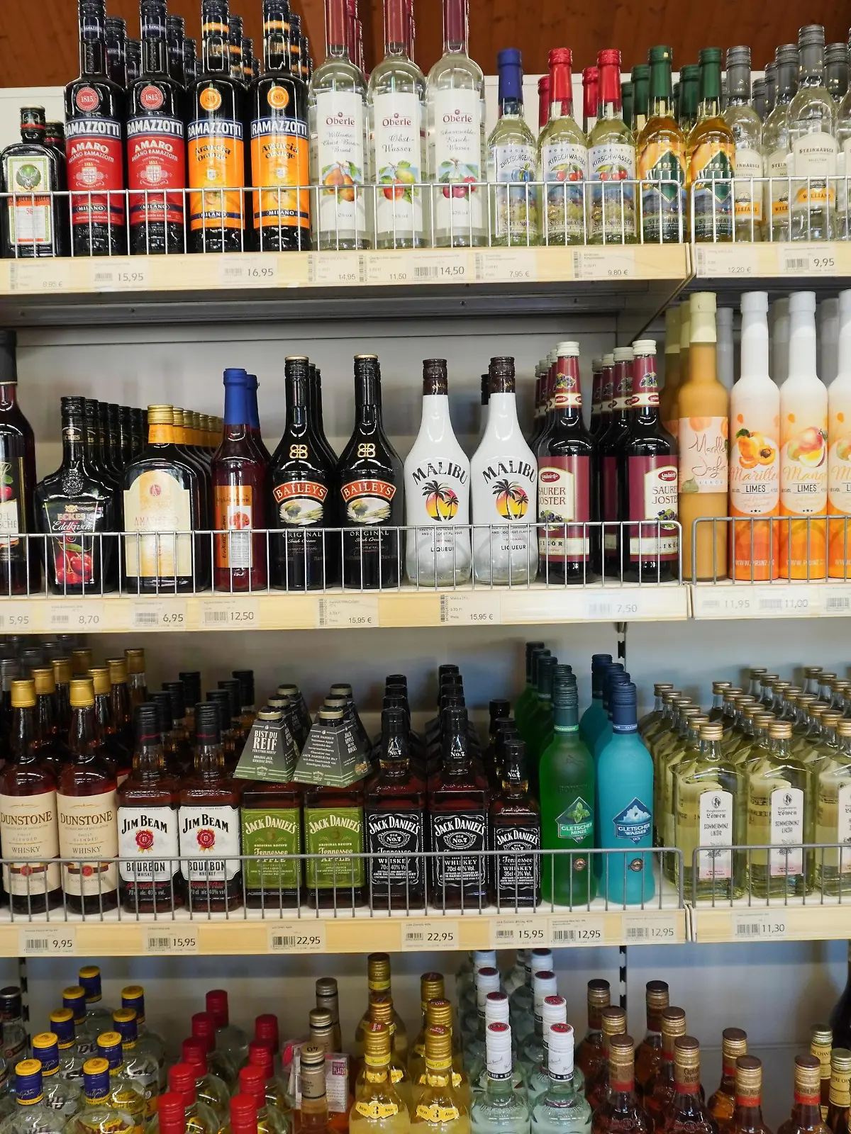 Zahlreiche Getränke mit Alkohol stehen fein säuberlich aufgereiht in einem Supermarkt.