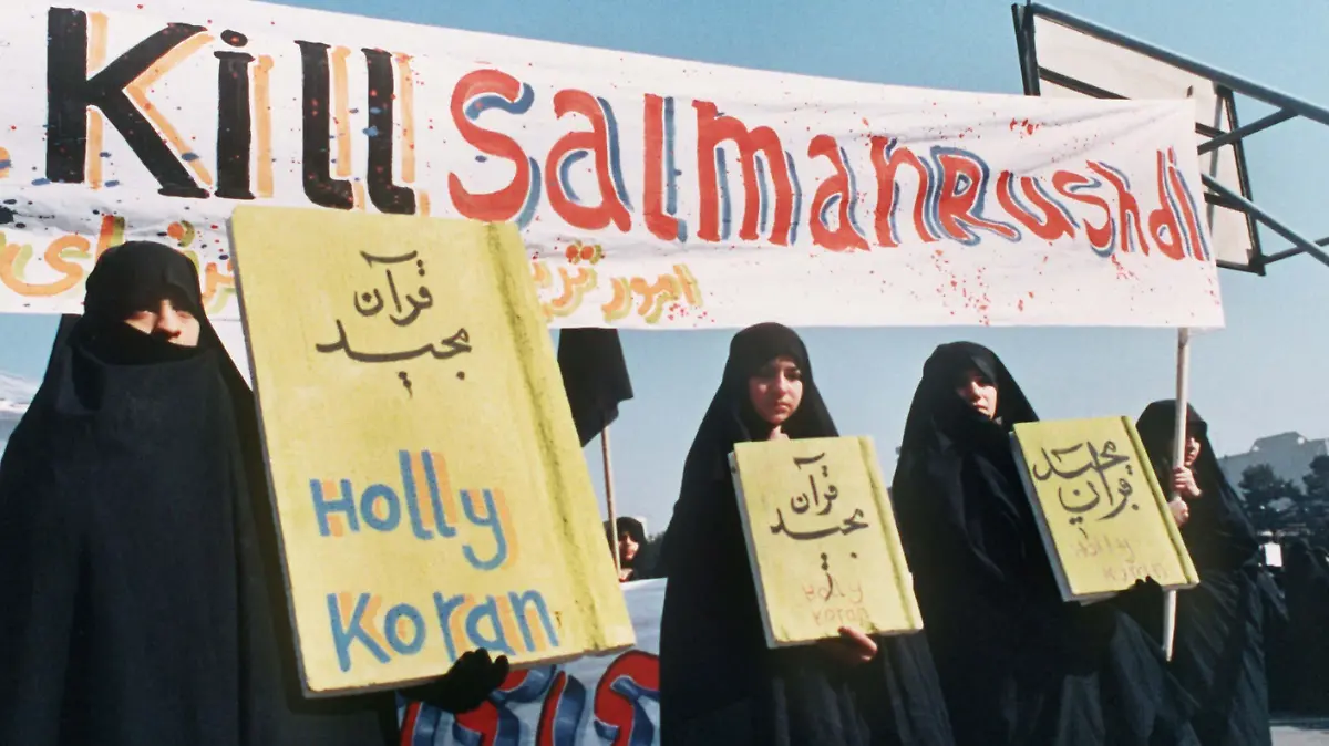 "Kill Salman Rushdie" ist auf einem Spruchband zu lesen, das iranische Frauen (Archivbild vom 17.2.1989) in Teheran bei einer Demonstration gegen den britischen Schriftsteller Salman Rushdie und sein Buch "Satanische Verse" mit sich führen. Der iranische Revolutionsführer Ayatollah Khomeini hatte kurz zuvor an alle Moslems den Appell gerichtet, Rushdie zu ermorden. Als «unhaltbaren Zustand» hat der Leiter des Verlags Kiepenheuer & Witsch, Reinhold Neven DuMont, die immer noch aufrecht erhaltene Morddrohung gegen den Schriftsteller bezeichnet. Iran habe die vor zehn Jahren (14. Februar) ausgesprochene Drohung gegen den britisch-indischen Autor immer noch nicht offiziell zurückgenommen. dpa (zu dpa 0020 vom 13.02.1999) +++ dpa-Bildfunk +++