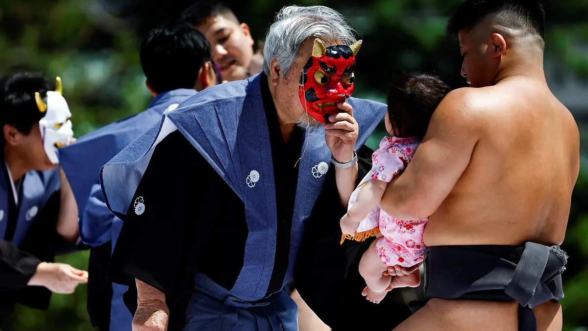 Ring assistants wear masks to scare babies held up by amateur sumo wrestlers during 'Nakizumo' or a baby-crying sumo contest, where two wrestlers hold a baby each and a referee makes faces and loud noises to make them cry and determines the winner based on the loudest baby, at Sensoji temple in Tokyo, Japan, April 28, 2024. The ritual is believed to aid the healthy growth of the children and ward off evil spirits. REUTERS/Issei Kato