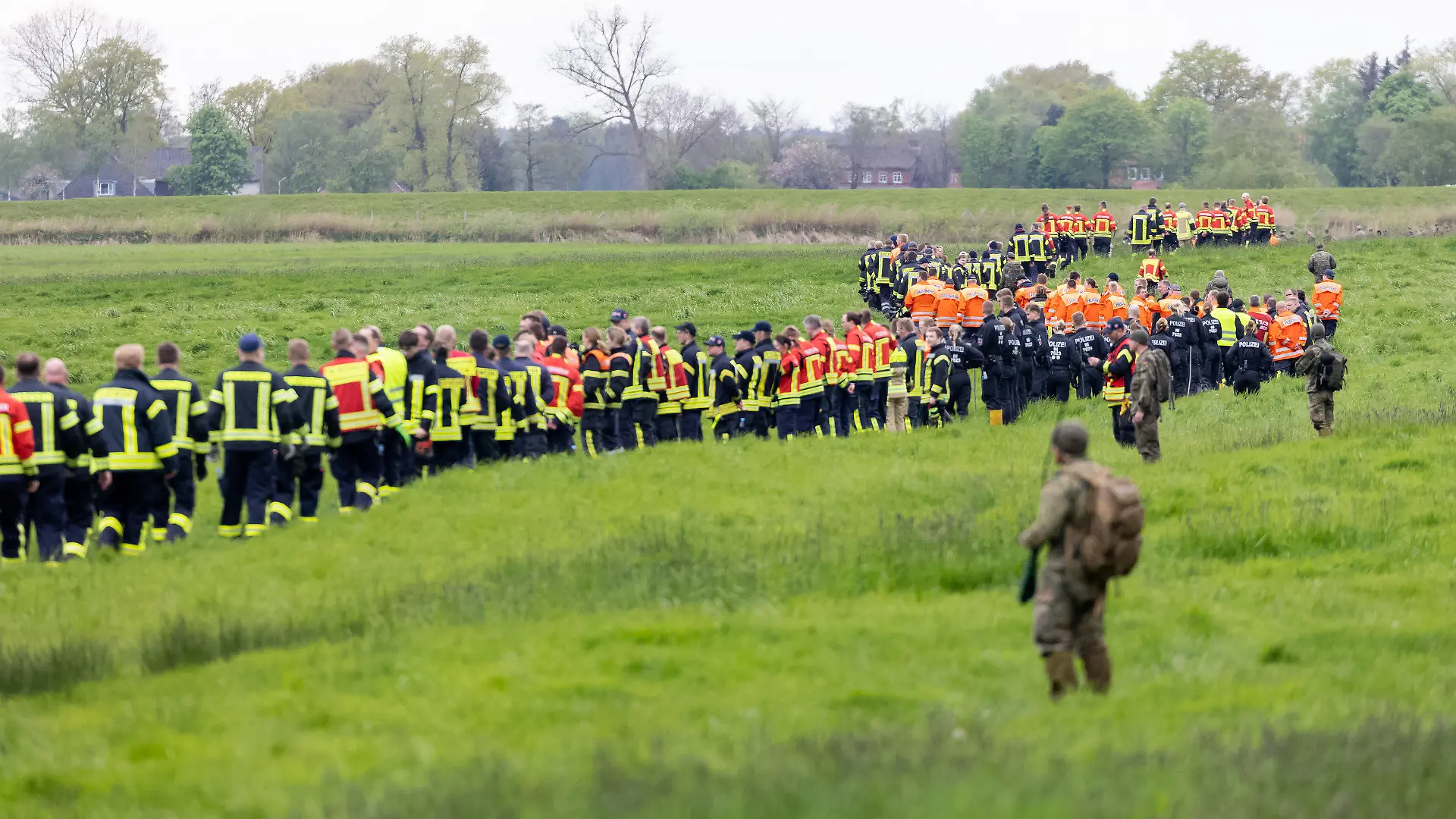 28.04.2024, Niedersachsen, Gräpel: Soldaten der Bundeswehr und Einsatzkräfte von Feuerwehr und Polizei stellen sich auf, um ein Feld abzusuchen. Der sechs Jahre alte Arian aus Elm, einem Ortsteil von Bremervörde, wird noch immer vermisst. Die Suche nach ihm geht weiter. Foto: Bodo Marks/dpa +++ dpa-Bildfunk +++
