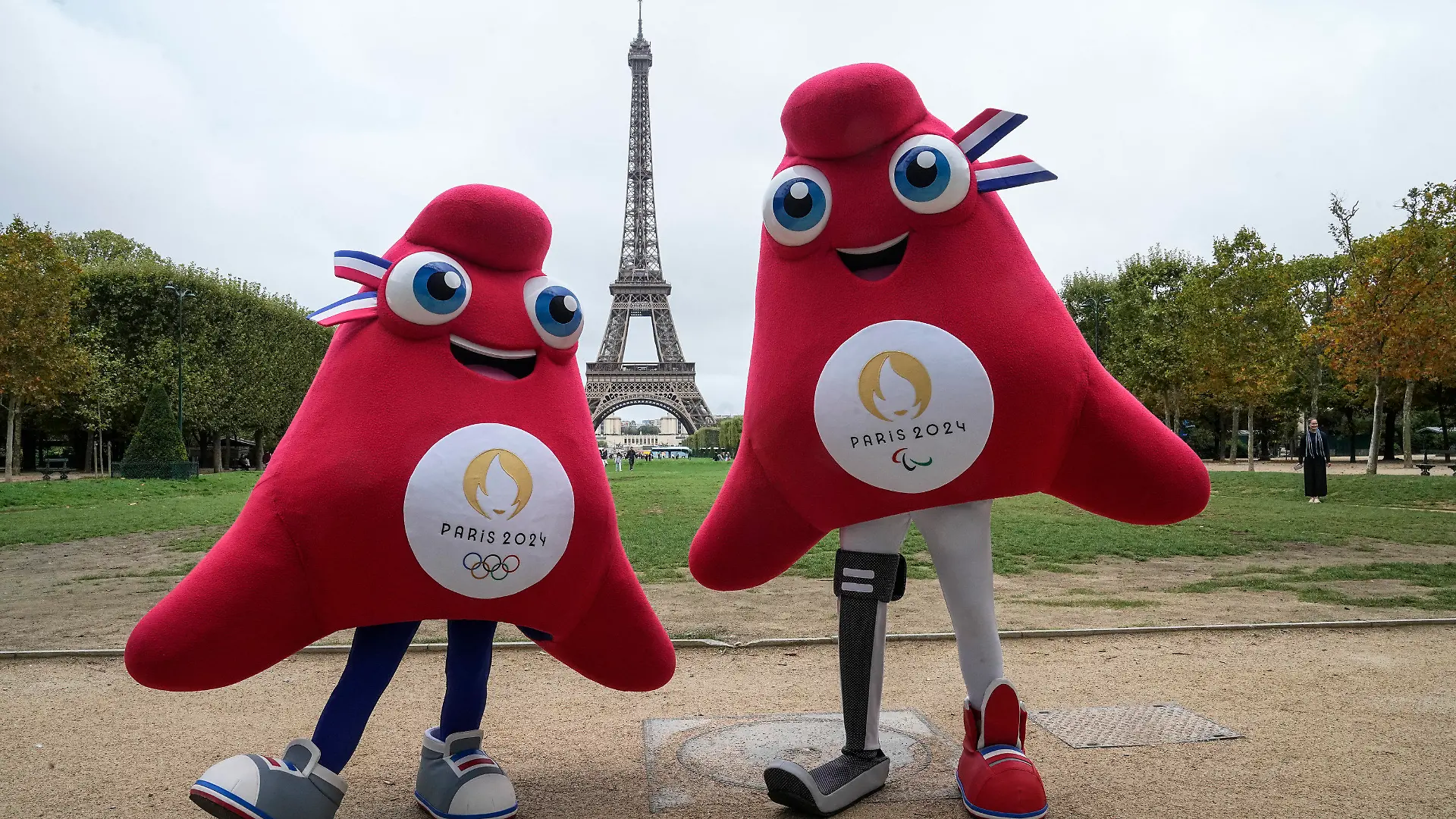 ARCHIV - 28.08.2023, Frankreich, Paris: Die Maskottchen der Olympischen (l) und Paralympischen Spiele Paris 2024 stehen vor dem Eiffelturm. (zu dpa: «Frankreich um maximale Sicherheit für Olympia in Paris bemüht») Foto: Michel Euler/AP/dpa +++ dpa-Bildfunk +++