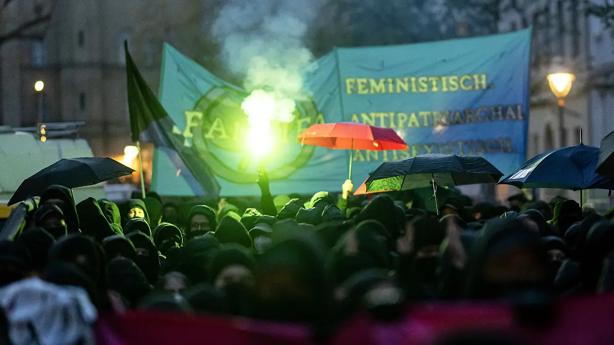 Teilnehmerinnen der linken Demonstration «Take back the night.» in Berlin-Kreuzberg verwenden 2023 Regenschirme als Sichtschutz.