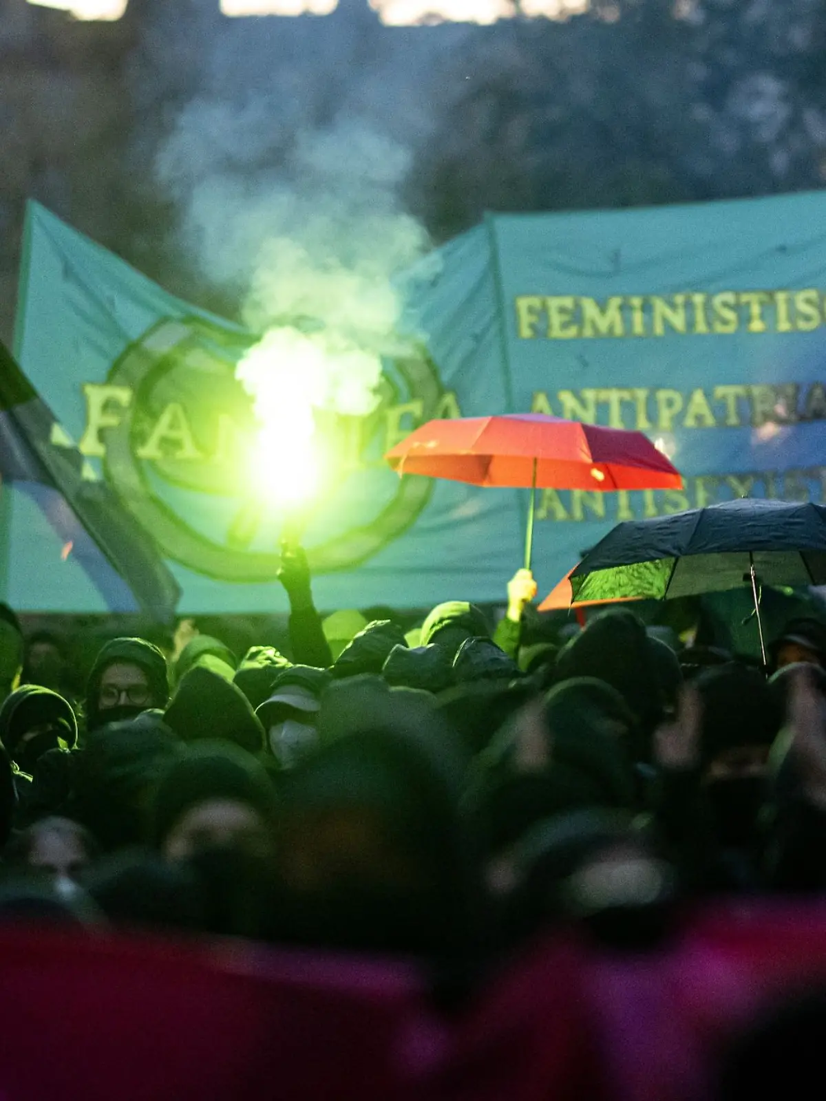 Teilnehmerinnen der linken Demonstration «Take back the night.» in Berlin-Kreuzberg verwenden 2023 Regenschirme als Sichtschutz.