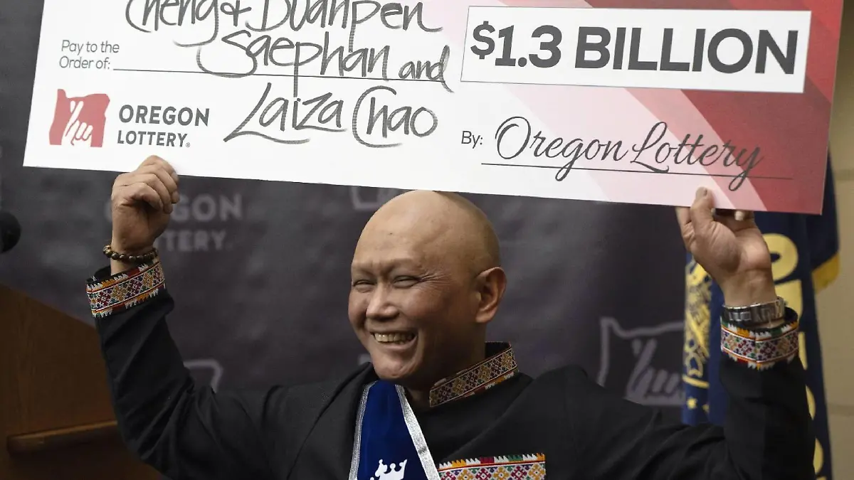 Cheng "Charlie" Saephan hält einen übergroßen Scheck über seinen Kopf.