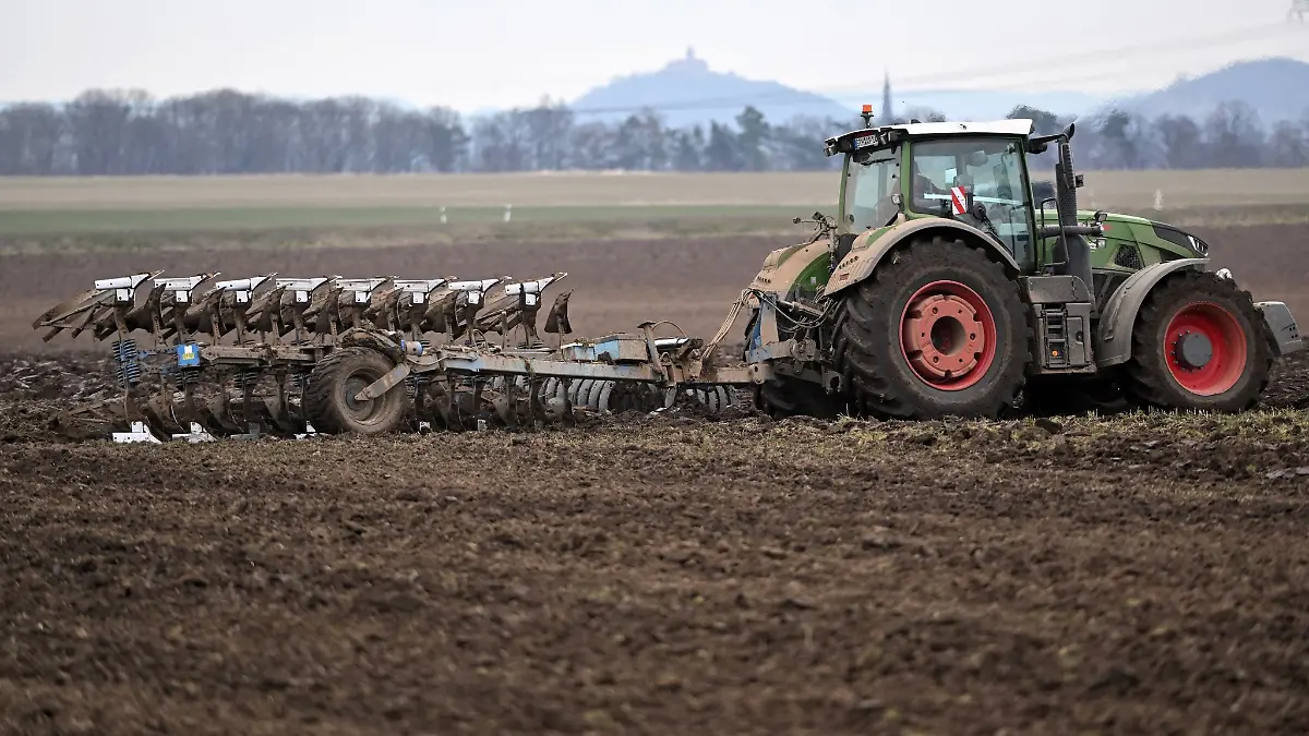 Ein Traktor zieht einen Pflug über ein Feld nahe Gotha.