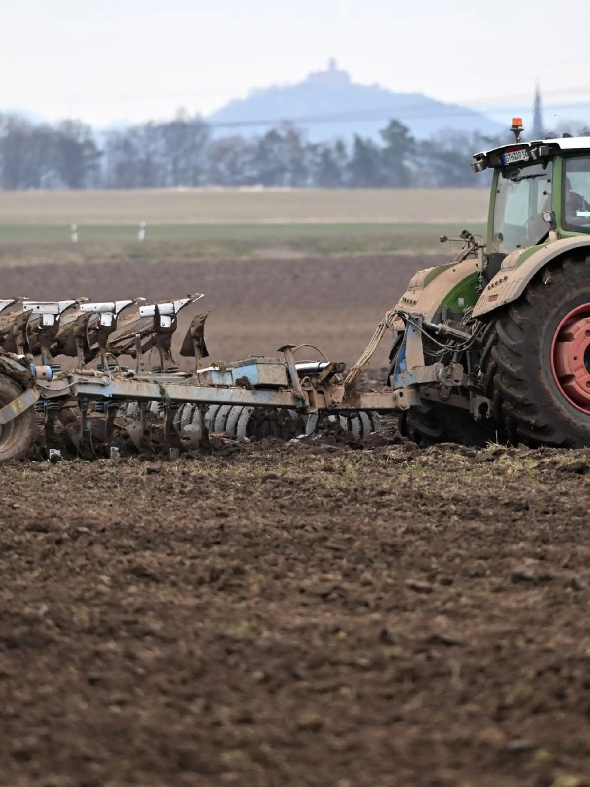 Ein Traktor zieht einen Pflug über ein Feld nahe Gotha.