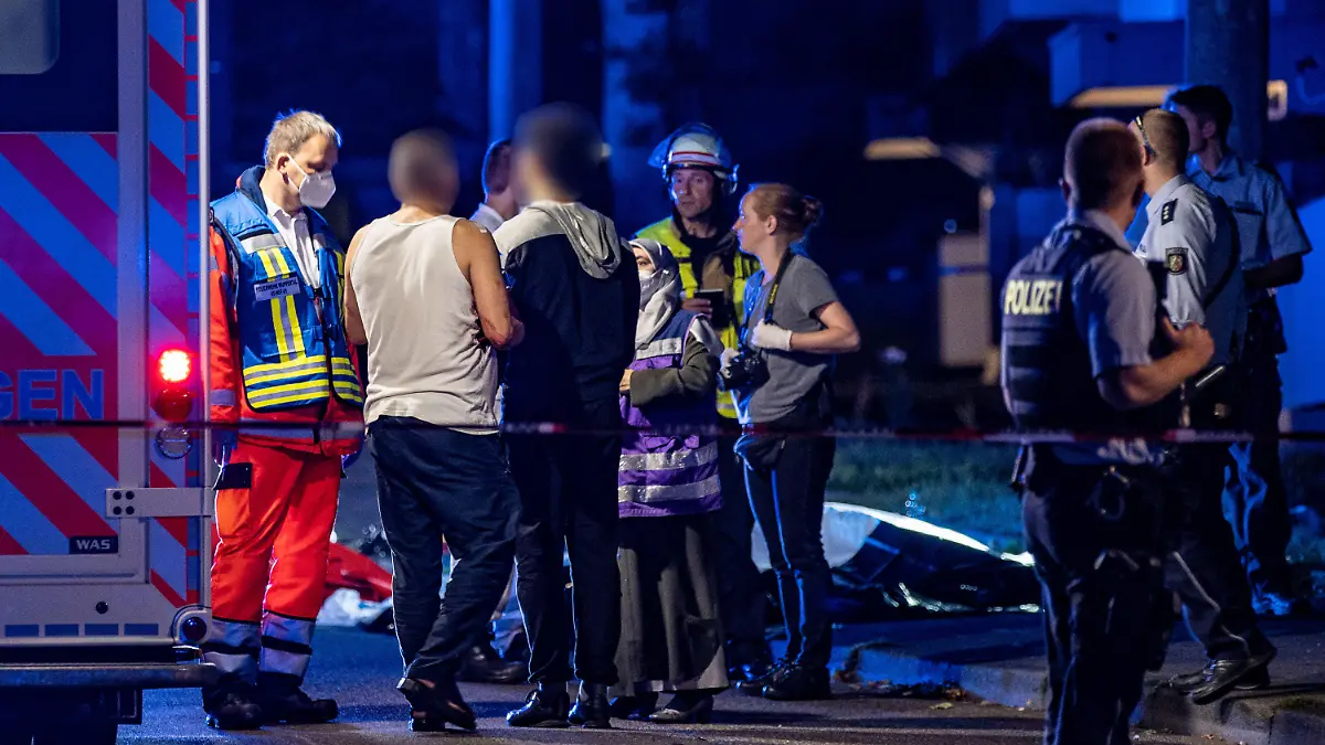 10.08.2022, Nordrhein-Westfalen, Solingen: Eine muslimische Notfallseelsorgerin trifft am Tatort ein und redet mit einem verletzten Mann. Ein 31 Jahre alter Mann ist bei einer Messerstecherei am Mittwochabend in Solingen tödlich verletzt worden. Trotz Reanimationsversuchen durch die Einsatzkräfte sei der Mann am Tatort gestorben, teilte eine Polizeisprecherin mit. Mindestens zwei weitere Personen seien ebenfalls verletzt worden. Ein männlicher Tatverdächtiger wurde am Tatort festgenommen. Genauere Angaben zu den Hintergründen der Tat machte die Polizei bislang nicht. Die Mordkommission hat die Ermittlungen aufgenommen. Foto: Christoph Reichwein/dpa +++ dpa-Bildfunk +++