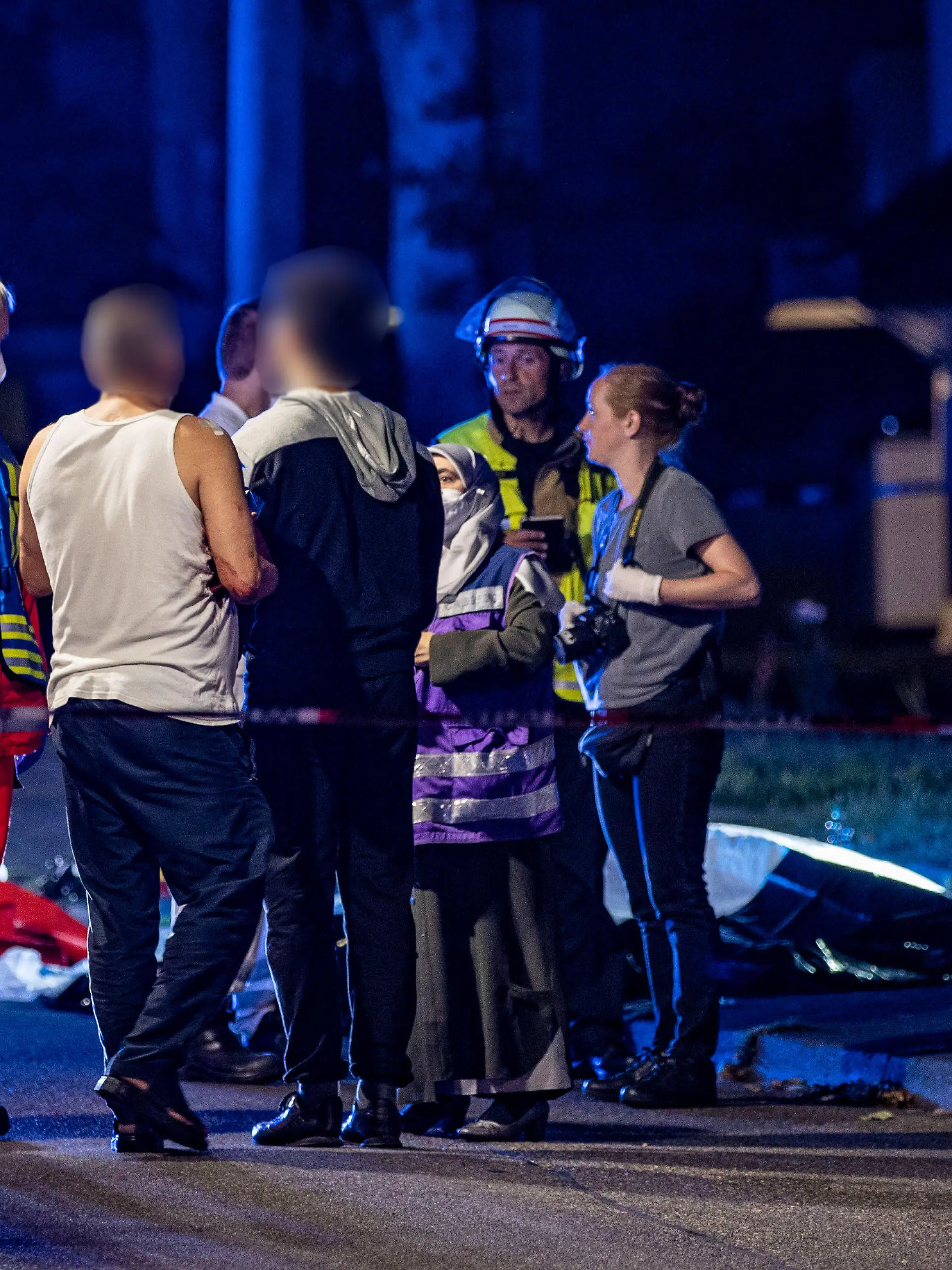 10.08.2022, Nordrhein-Westfalen, Solingen: Eine muslimische Notfallseelsorgerin trifft am Tatort ein und redet mit einem verletzten Mann. Ein 31 Jahre alter Mann ist bei einer Messerstecherei am Mittwochabend in Solingen tödlich verletzt worden. Trotz Reanimationsversuchen durch die Einsatzkräfte sei der Mann am Tatort gestorben, teilte eine Polizeisprecherin mit. Mindestens zwei weitere Personen seien ebenfalls verletzt worden. Ein männlicher Tatverdächtiger wurde am Tatort festgenommen. Genauere Angaben zu den Hintergründen der Tat machte die Polizei bislang nicht. Die Mordkommission hat die Ermittlungen aufgenommen. Foto: Christoph Reichwein/dpa +++ dpa-Bildfunk +++