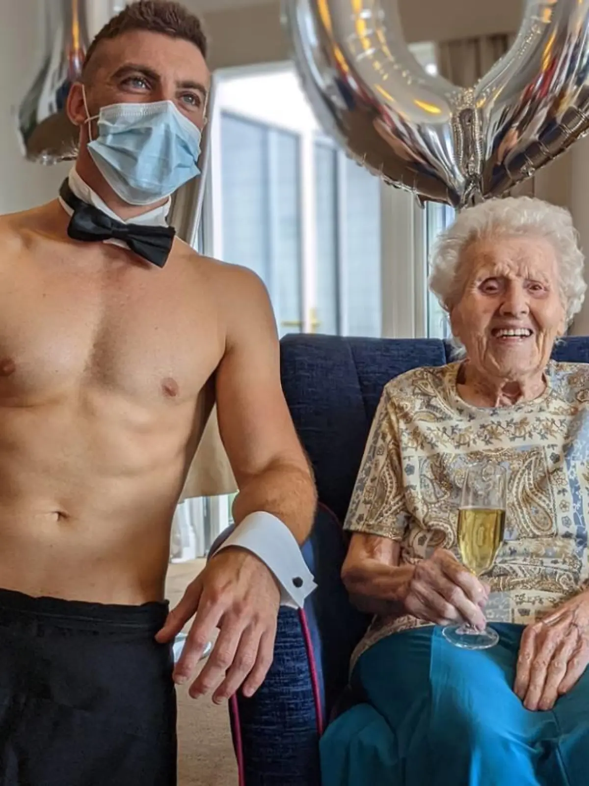 Norah Shaw sitzt neben dem Nackt-Butler und lacht