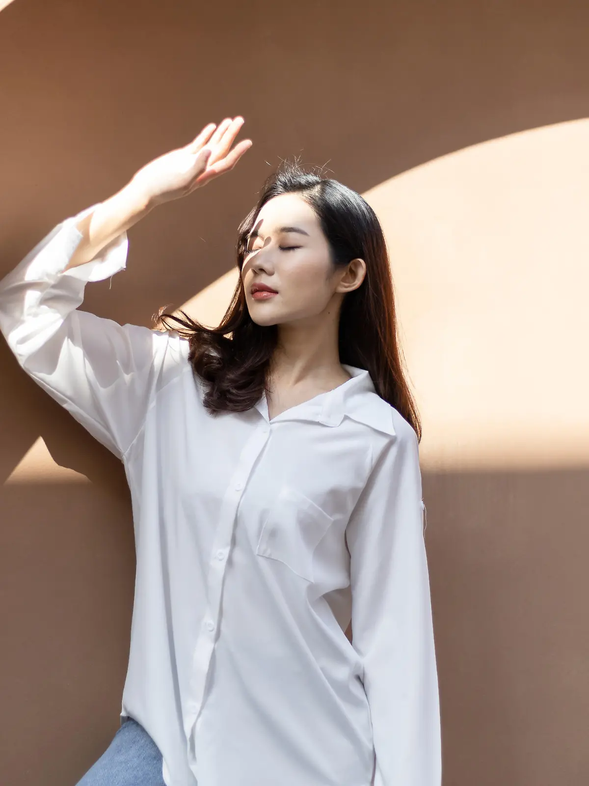 Portrait of a beautiful Asian woman with healthy skin. She uses a sun protection hand that hits her face to protect against UV that has caused her face to dull.
