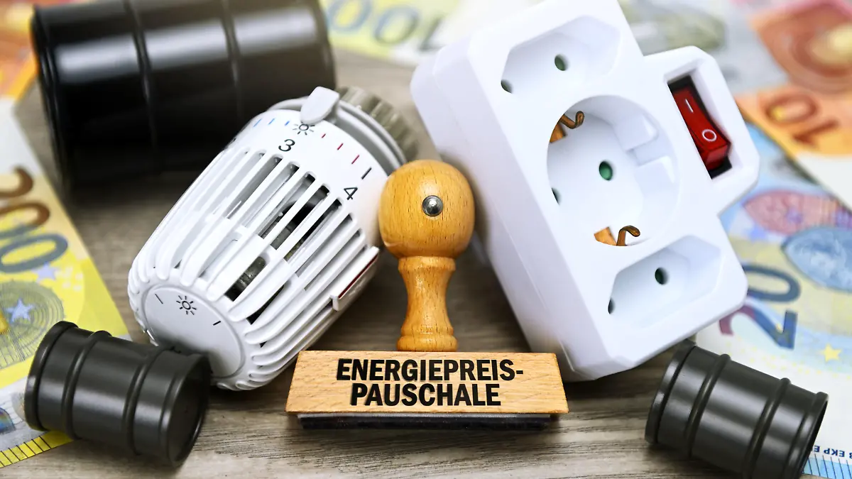 Stempel mit Aufschrift Energiepreispauschale vor Heizungsthermostat, Steckdose und Ölfässern / action press