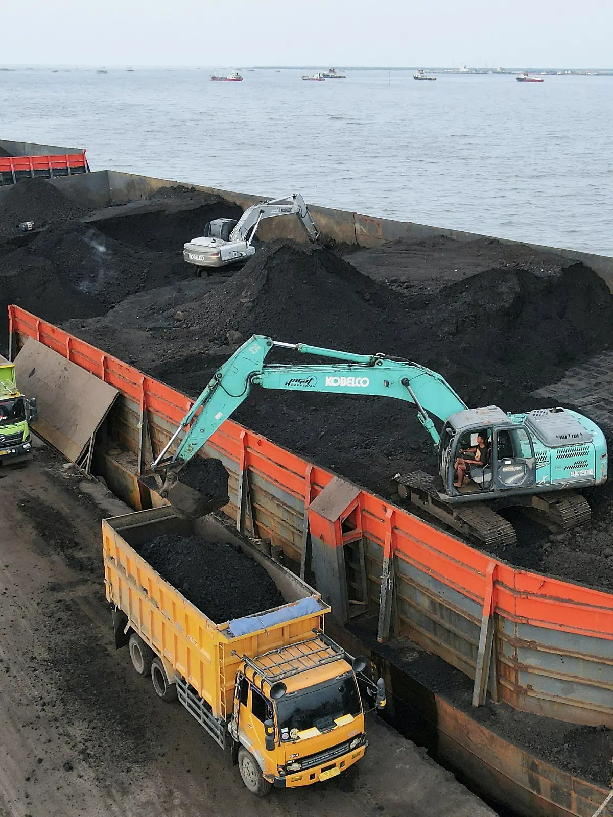 FILE PHOTO: A worker operates a heavy vehicle for unloading coal from the barge into a truck to be distributed, at the Karya Citra Nusantara port in North Jakarta, Indonesia, January 13, 2022. Picture taken with a drone, January 13, 2022. REUTERS/Willy Kurniawan/File Photo
