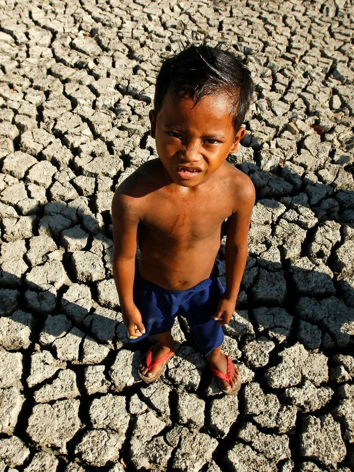 FILE - A Filipino boy plays in a dried fish pond bed at the outskirt of Paranaque City, south of Manila, Philippines, 06 March 2010. EPA/FRANCIS R. MALASIG  (zu dpa 
"Große Mehrheit der Weltbevölkerung will Klimaabkommen" vom 05.11.2015) +++(c) dpa - Bildfunk+++
