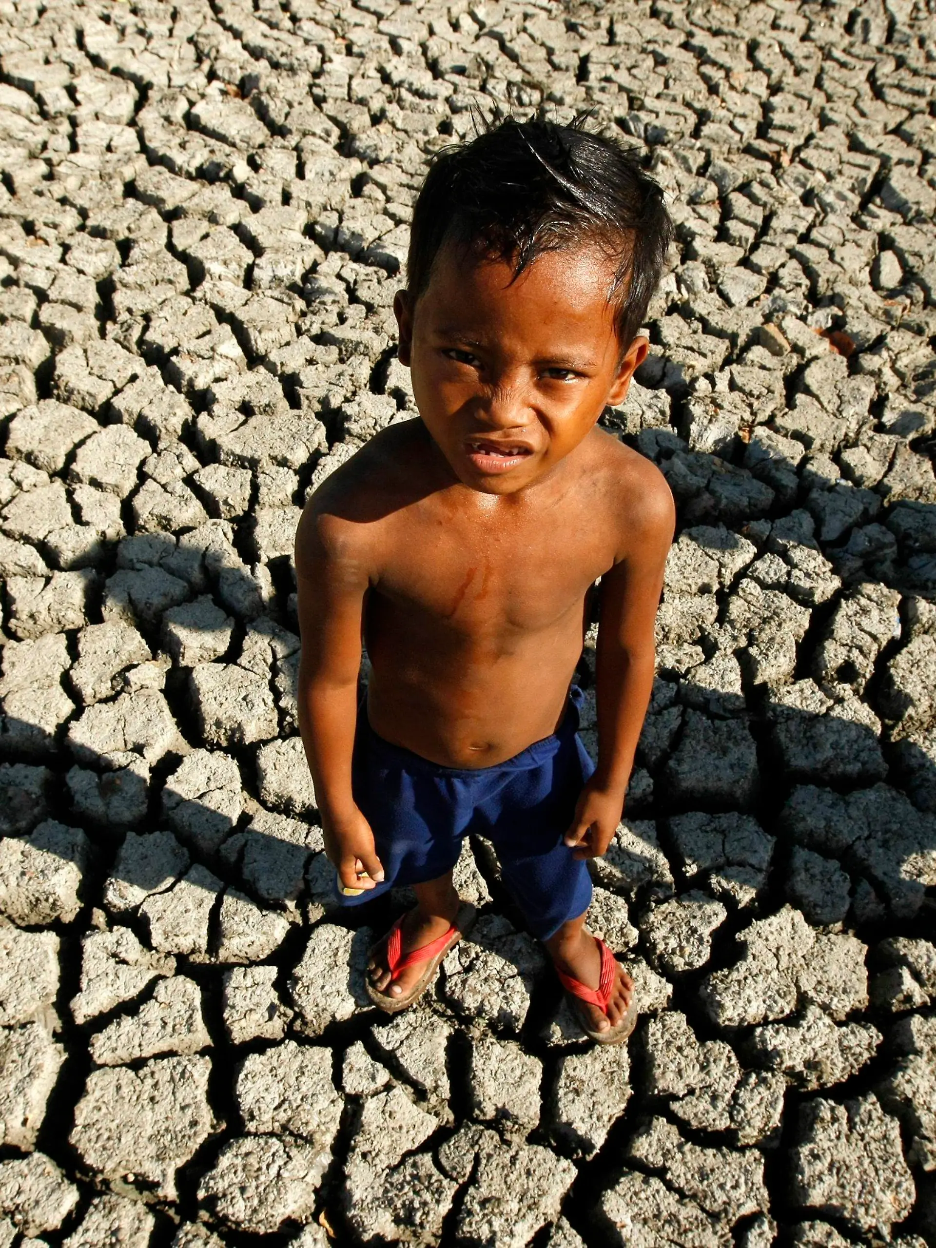 FILE - A Filipino boy plays in a dried fish pond bed at the outskirt of Paranaque City, south of Manila, Philippines, 06 March 2010. EPA/FRANCIS R. MALASIG (zu dpa
"Große Mehrheit der Weltbevölkerung will Klimaabkommen" vom 05.11.2015) +++(c) dpa - Bildfunk+++