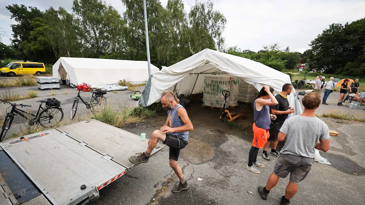 05.08.2022, Hamburg: Aktivistinnen und Aktivisten bauen ein Protestcamp verschiedener Umweltgruppen am Volkspark auf. Vom 09. August an sollen auf dem Gelände am Altonaer Volkspark bis zu 6000 Menschen eine Woche lang für mehr Klimaschutz demonstrieren. Zum ·System Change Camp· aufgerufen hat ein Bündnis aus mehr als 30 Gruppen. Foto: Christian Charisius/dpa - ACHTUNG: Nur zur redaktionellen Verwendung im Zusammenhang mit der aktuellen Berichterstattung und nur im vollen Ausschnitt zu verwenden. +++ dpa-Bildfunk +++