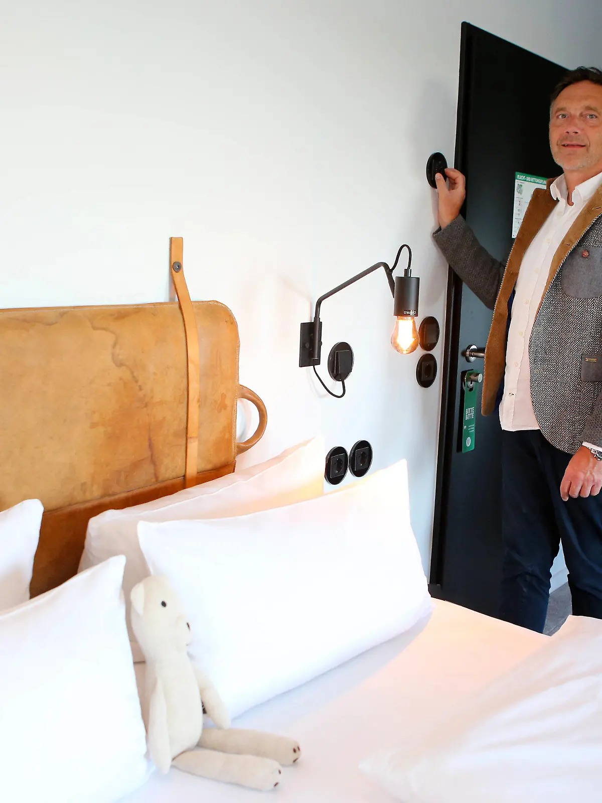 PRODUKTION - 08.08.2022, Niedersachsen, Braunlage: Meik Lindberg, Eigentümer des «The Hearts Hotel», stellt über ein Regelsystem die Temperatur in einem Hotelzimmer ein. Das Hotel kann die Ober- und Untergrenze der Temperatur zentral steuern. (zu dpa: «Pool, Heizung, Küche: Gastgewerbe sucht nach Energiesparmöglichkeiten») Foto: Stefan Rampfel/dpa +++ dpa-Bildfunk +++