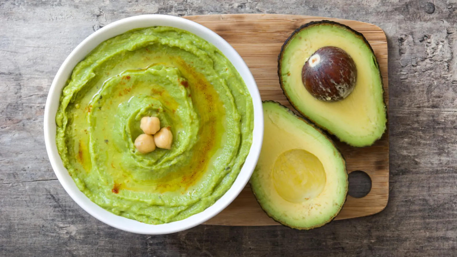 Avocado hummus in bowl on wooden background