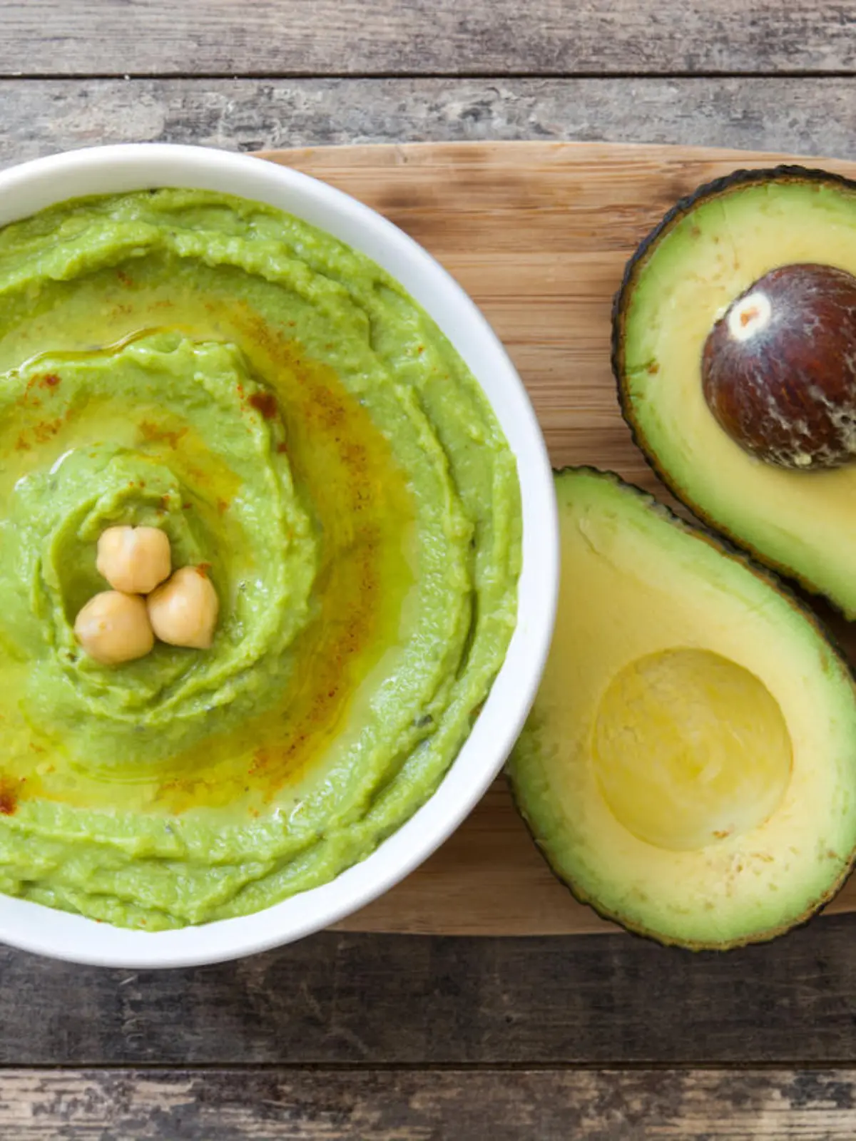 Avocado hummus in bowl on wooden background
