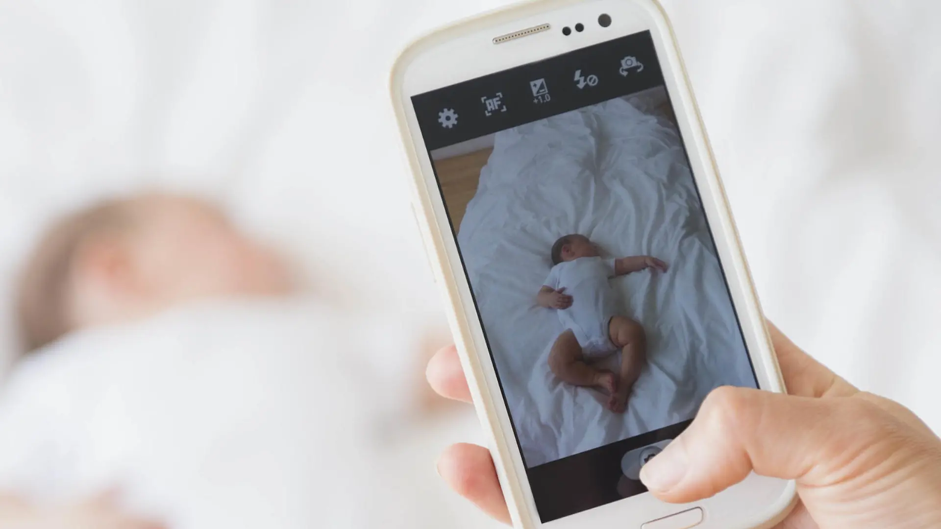 Mother photographing baby girl (2-5 months) sleeping in bed, , Mutter, die Baby-Maedchen (2-5 Monate) fotografiert, im Bett schlafend | Verwendung weltweit, Keine Weitergabe an Wiederverkäufer.