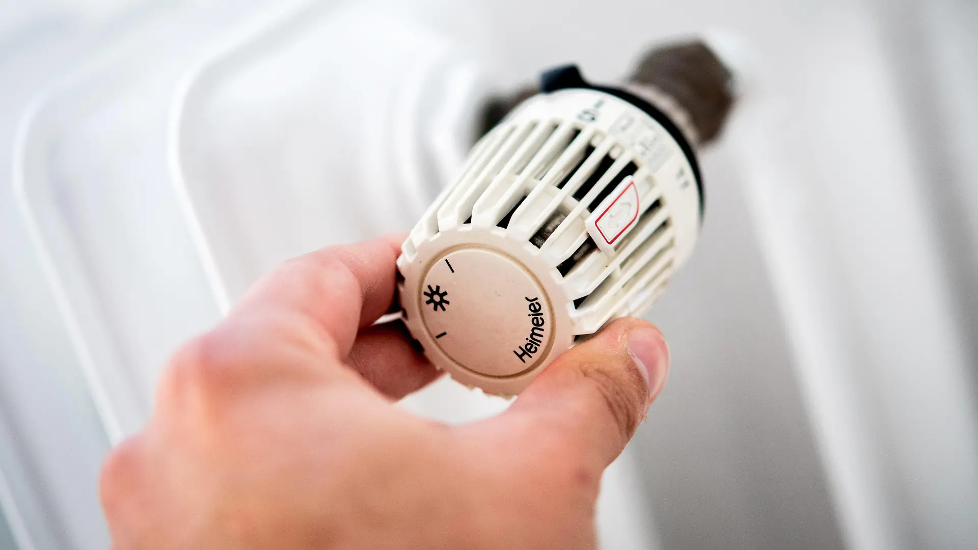 ARCHIV - 04.10.2021, Niedersachsen, Hannover: Ein Mann dreht in einer Wohnung am Thermostat einer Heizung. (zu dpa: «Bundesnetzagentur: Verbraucher müssen mehr Energie sparen») Foto: Hauke-Christian Dittrich/dpa +++ dpa-Bildfunk +++
