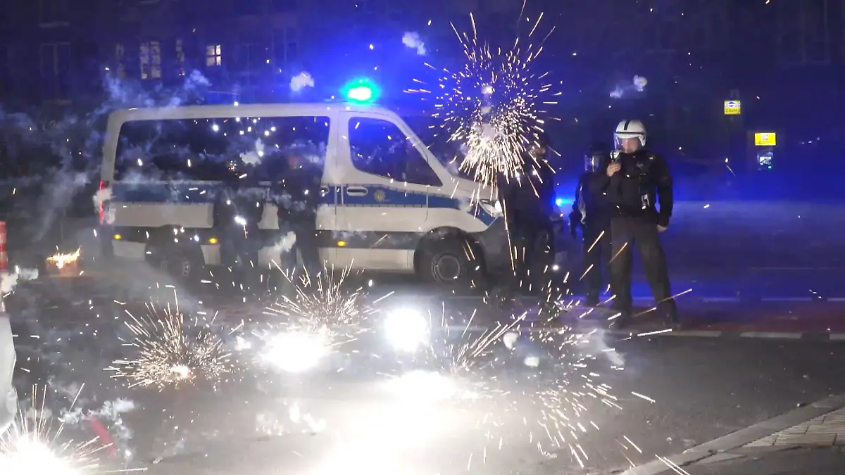 ARCHIV - 31.12.2022, Berlin: Polizeibeamte stehen hinter explodierendem Feuerwerk. (Zu dpa: «Prozess nach Silvester-Krawallen in Berlin») Foto: Julius-Christian Schreiner/TNN/dpa +++ dpa-Bildfunk +++