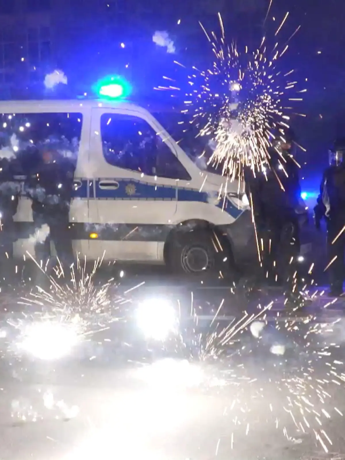 ARCHIV - 31.12.2022, Berlin: Polizeibeamte stehen hinter explodierendem Feuerwerk. (Zu dpa: «Prozess nach Silvester-Krawallen in Berlin») Foto: Julius-Christian Schreiner/TNN/dpa +++ dpa-Bildfunk +++