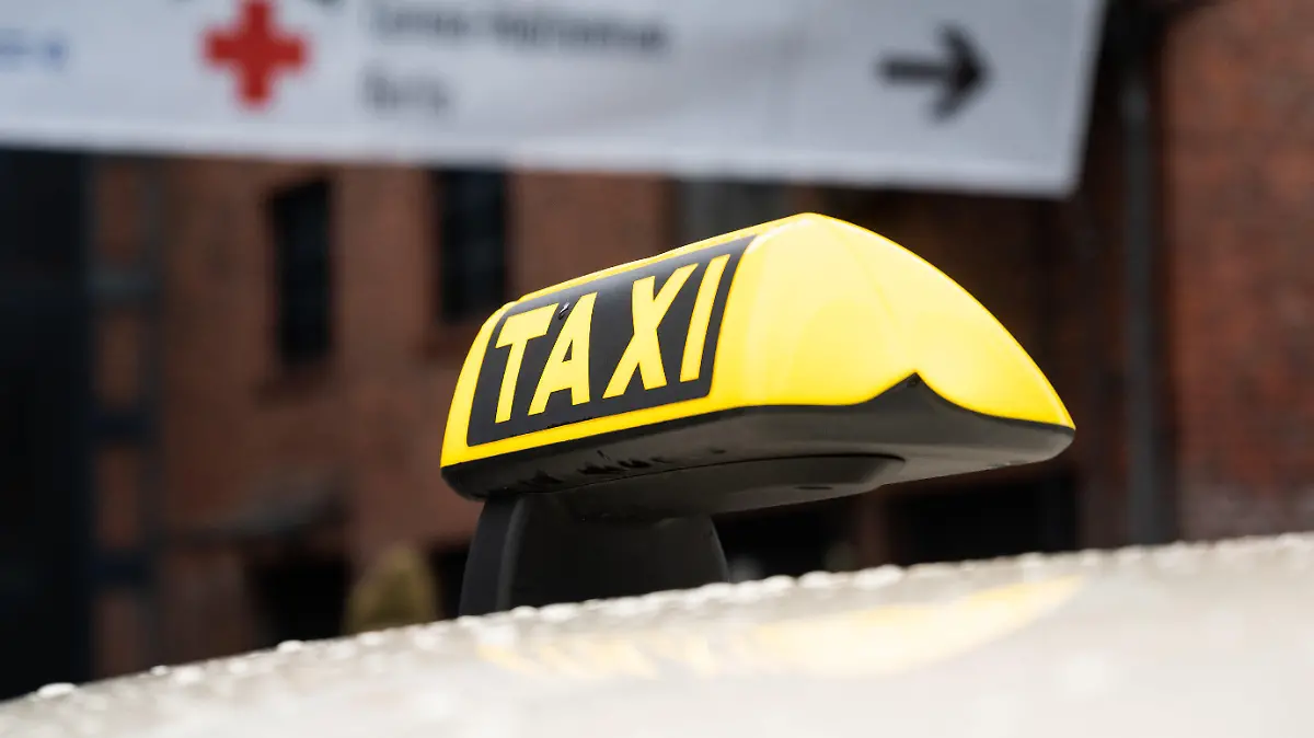 04.01.2021, Berlin: Vor dem Impfzentrum in der Treptow Arena, für die Impfung gegen das Corona-Virus, steht ein Taxi. Berliner, die mindestens 90 Jahre alt sind und einen Termin im Impfzentrum in Berlin-Treptow haben, können kostenlos mit dem Taxi dort hin fahren. Foto: Christophe Gateau/dpa +++ dpa-Bildfunk +++