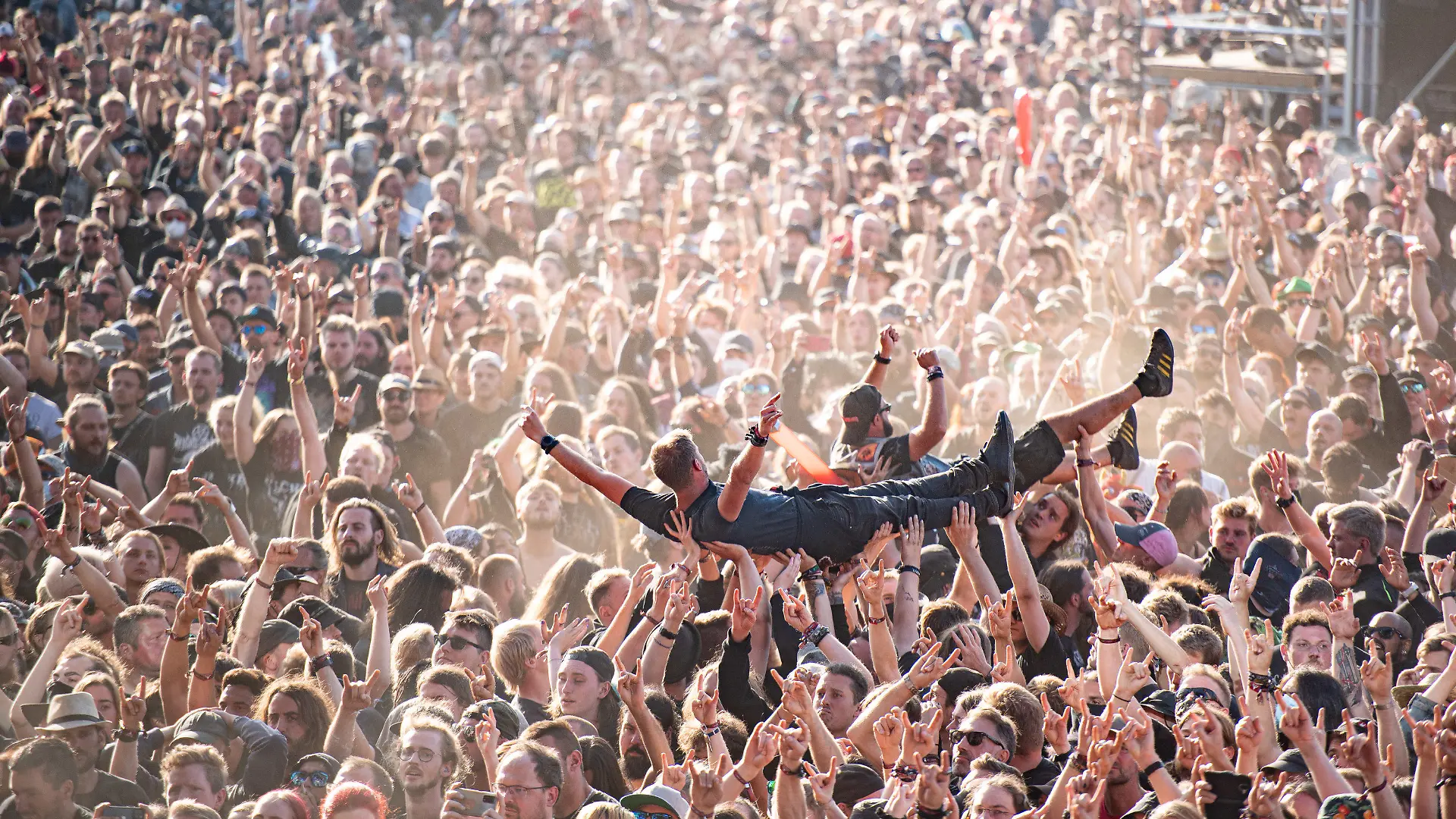 06.08.2022, Schleswig-Holstein, Wacken: Festivalbesucher werden beim Wacken Open Air Festival beim Crowdsurfen über die Menge getragen. Das WOA gilt als größtes Heavy-Metal-Festival der Welt. Foto: Daniel Reinhardt/dpa +++ dpa-Bildfunk +++