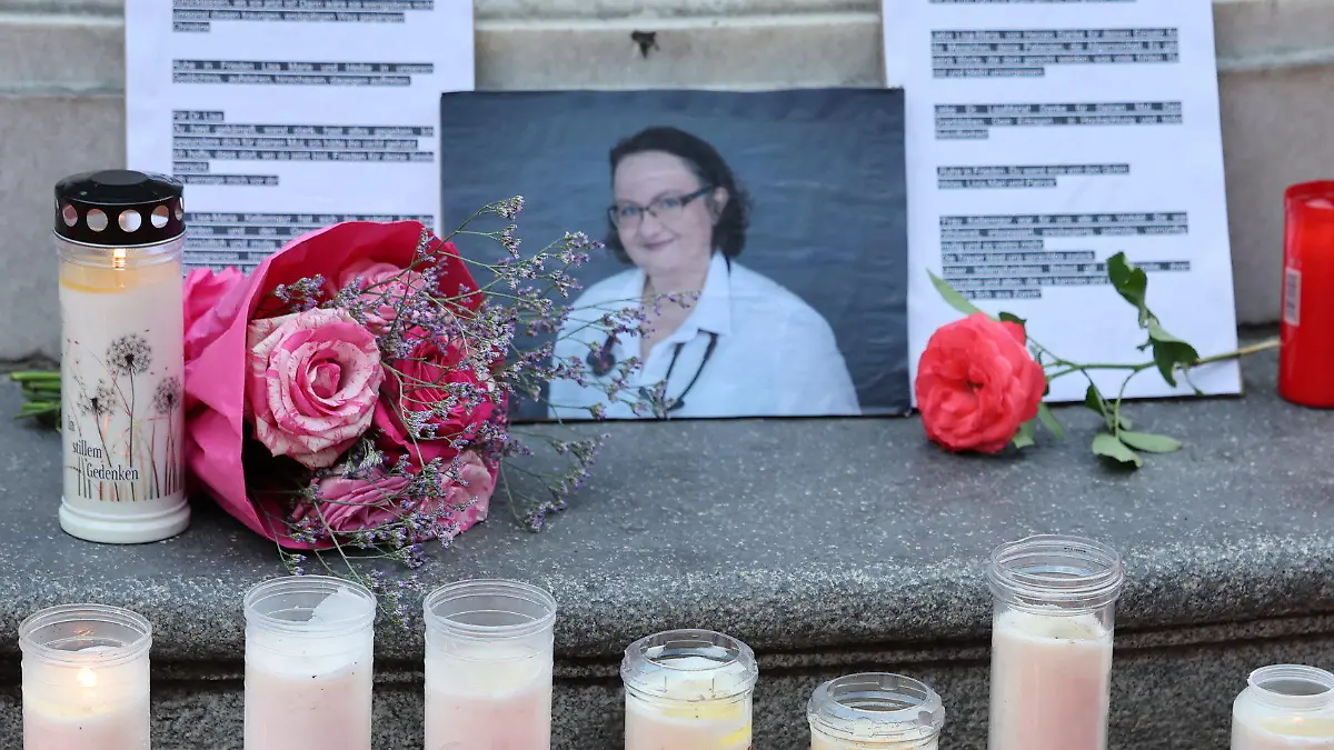 01.08.2022, Österreich, Linz: Kerzen, Blumen und ein Foto sind bei einer Gedenkveranstaltung der Initiative #YesWeCare in Erinnerung an die oberösterreichische Ärztin Lisa-Maria Kellermayr in Linz zu sehen. Der Tod von Lisa-Maria Kellermayr, die zuletzt wegen Morddrohungen aus der Szene der Impfgegner ihre Praxis geschlossen hat, hat tiefe Betroffenheit ausgelöst. Foto: Fotokerschi.At/Hannes Draxler/APA/dpa - ACHTUNG: Nur zur redaktionellen Verwendung im Zusammenhang mit einer aktuellen Berichterstattung und nur volles Format, kein Ausschnitt und nur mit vollständiger Nennung des vorstehenden Credits +++ dpa-Bildfunk +++