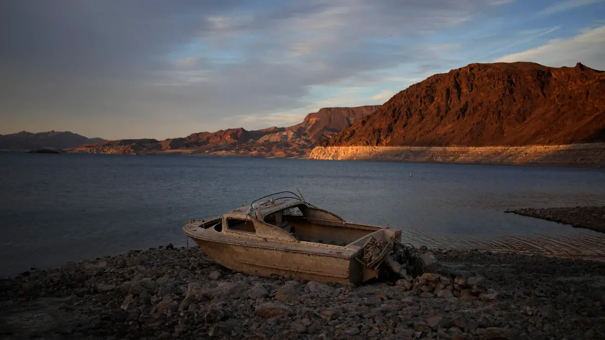 FILE - A formerly sunken boat sits high and dry along the shoreline of Lake Mead at the Lake Mead National Recreation Area, on May 10, 2022, near Boulder City, Nev. Wildfires, floods and soaring temperatures have made climate change real to many Americans. Yet a sizeable number continue to dismiss the scientific consensus that human activity is to blame. That's in part because of a decades-long campaign by fossil fuel companies to muddy the facts and promote fringe explanations. (AP Photo/John Locher, File)