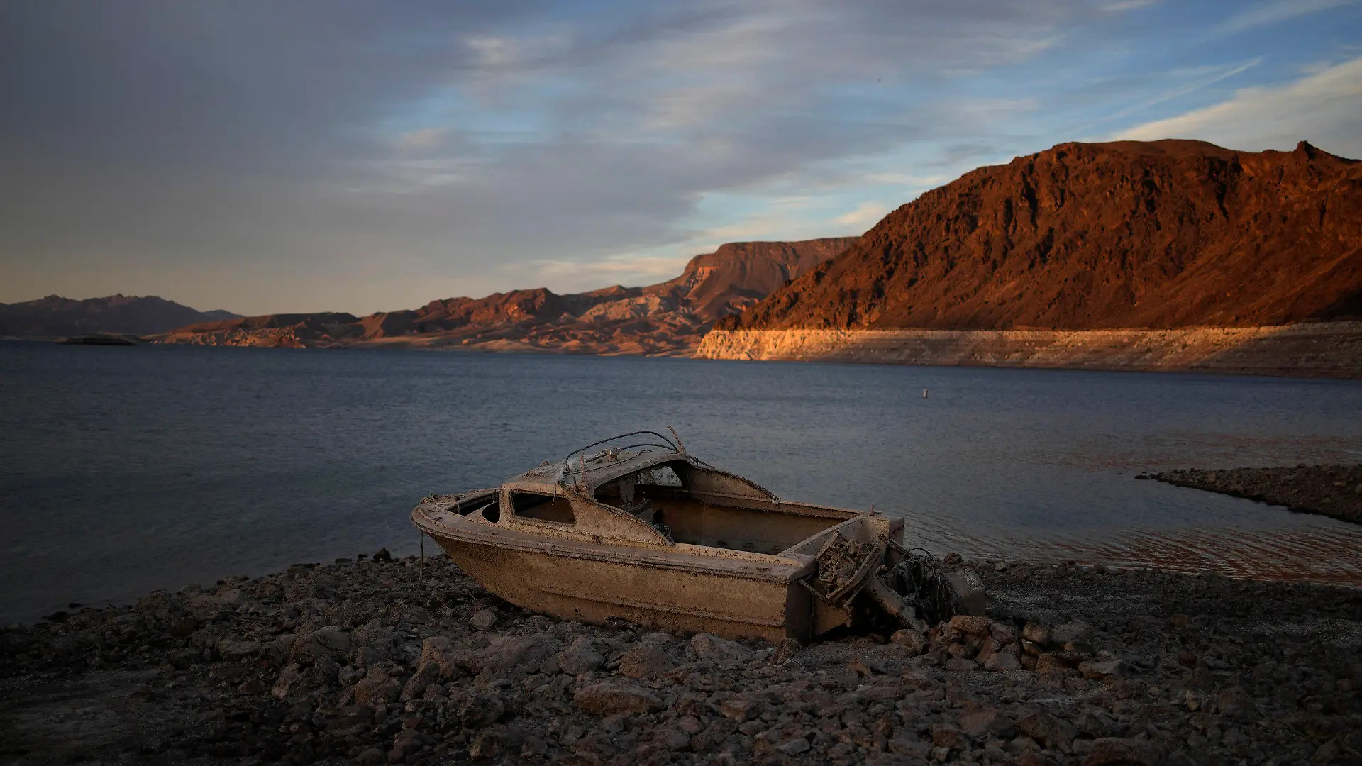 FILE - A formerly sunken boat sits high and dry along the shoreline of Lake Mead at the Lake Mead National Recreation Area, on May 10, 2022, near Boulder City, Nev. Wildfires, floods and soaring temperatures have made climate change real to many Americans. Yet a sizeable number continue to dismiss the scientific consensus that human activity is to blame. That's in part because of a decades-long campaign by fossil fuel companies to muddy the facts and promote fringe explanations. (AP Photo/John Locher, File)