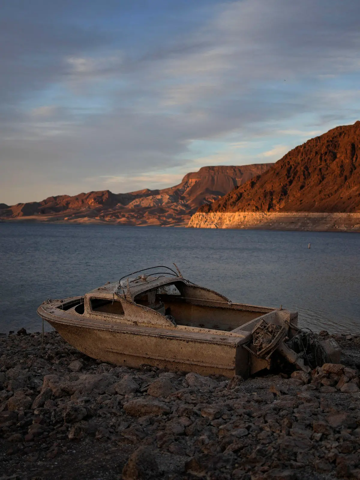 FILE - A formerly sunken boat sits high and dry along the shoreline of Lake Mead at the Lake Mead National Recreation Area, on May 10, 2022, near Boulder City, Nev. Wildfires, floods and soaring temperatures have made climate change real to many Americans. Yet a sizeable number continue to dismiss the scientific consensus that human activity is to blame. That's in part because of a decades-long campaign by fossil fuel companies to muddy the facts and promote fringe explanations. (AP Photo/John Locher, File)