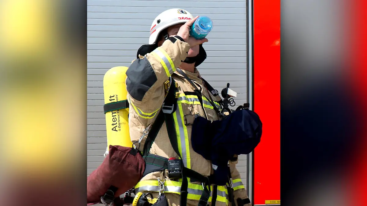 Ein Berliner Feuerwehrmann trinkt Mineralwasser während einer Notfallübung.