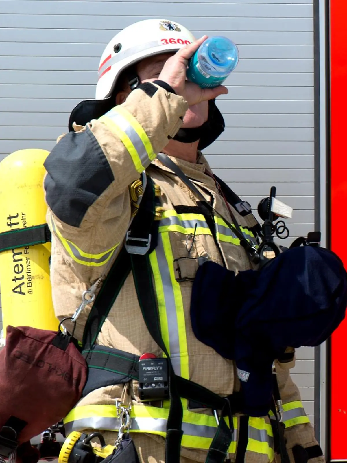 Ein Berliner Feuerwehrmann trinkt Mineralwasser während einer Notfallübung.