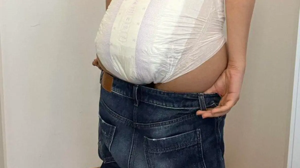 Eine Frau posiert mit heruntergelassener Jeans und Windel.